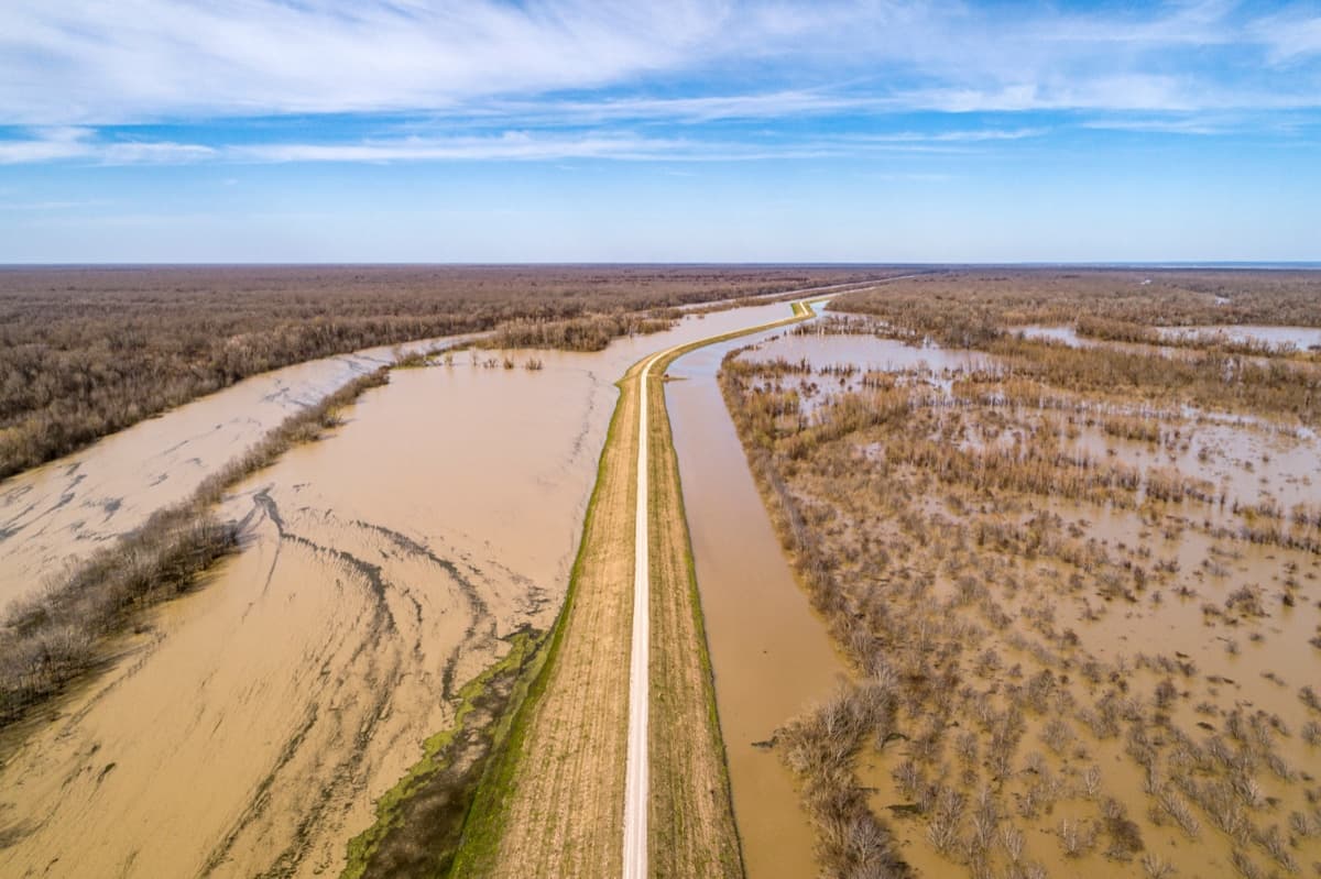 Floodwater covering farmland either side of a raised road