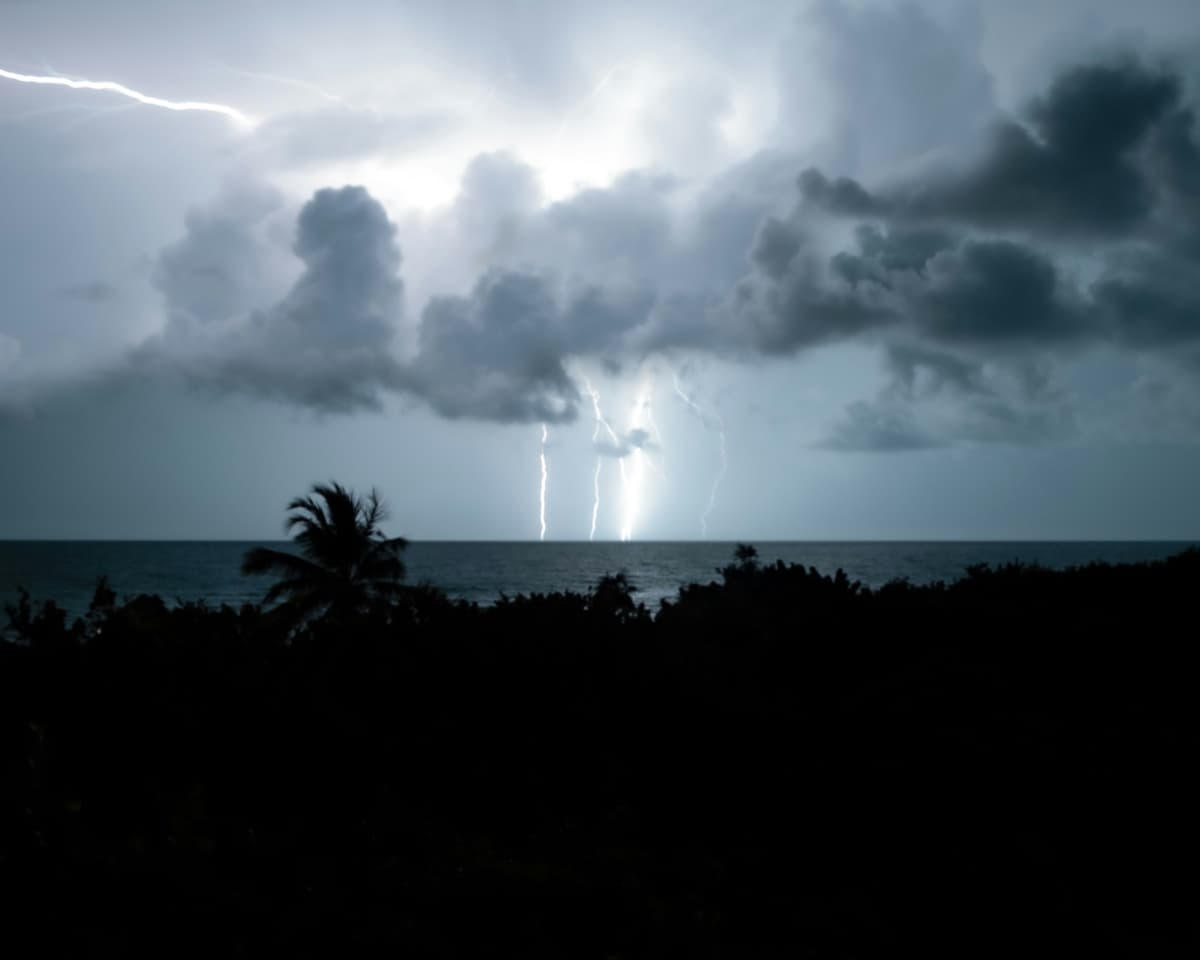 Lightning striking from a storm front at dusk