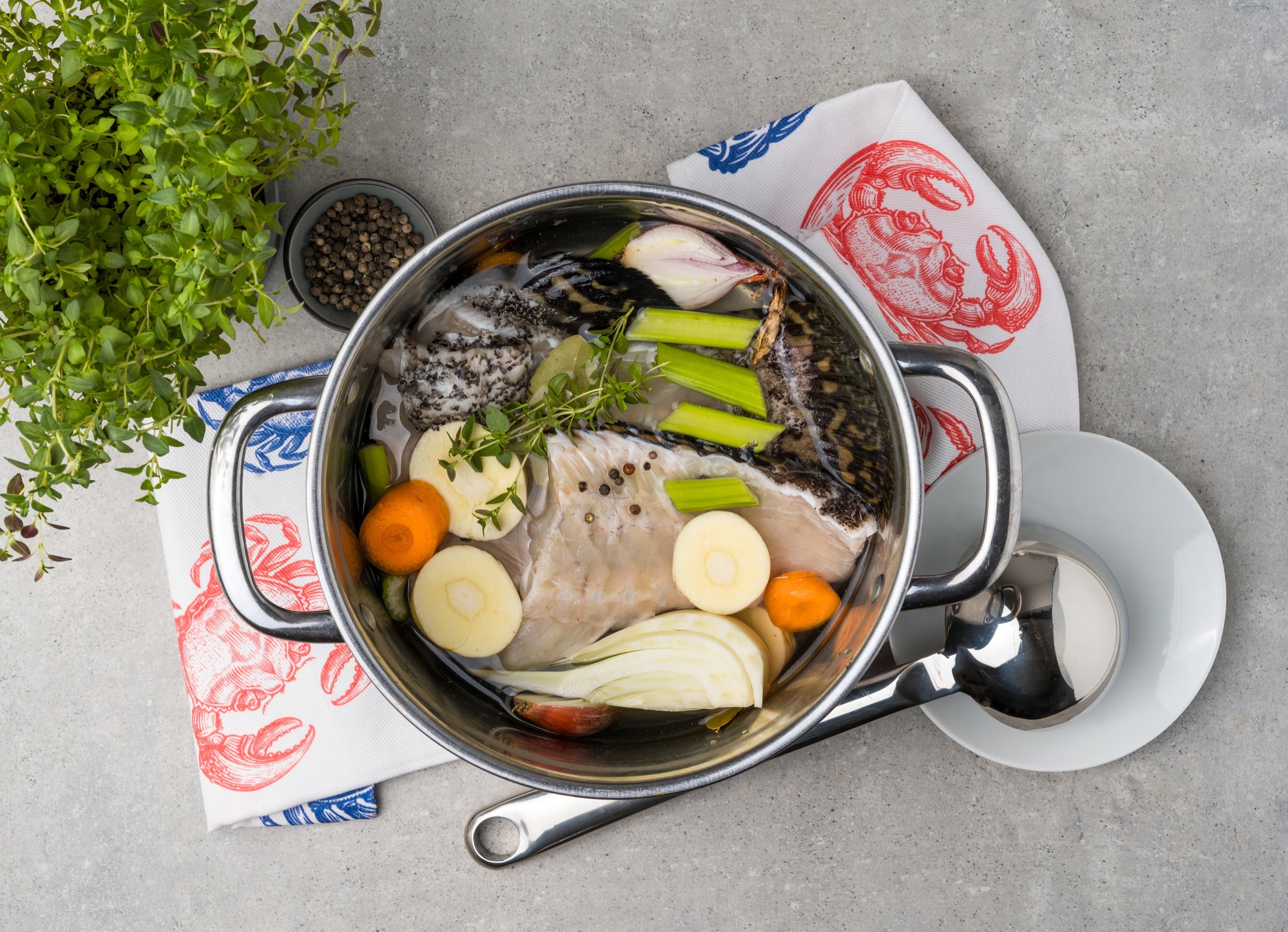 Grouper carcasses simmering with vegetables and herbs in a stock pot