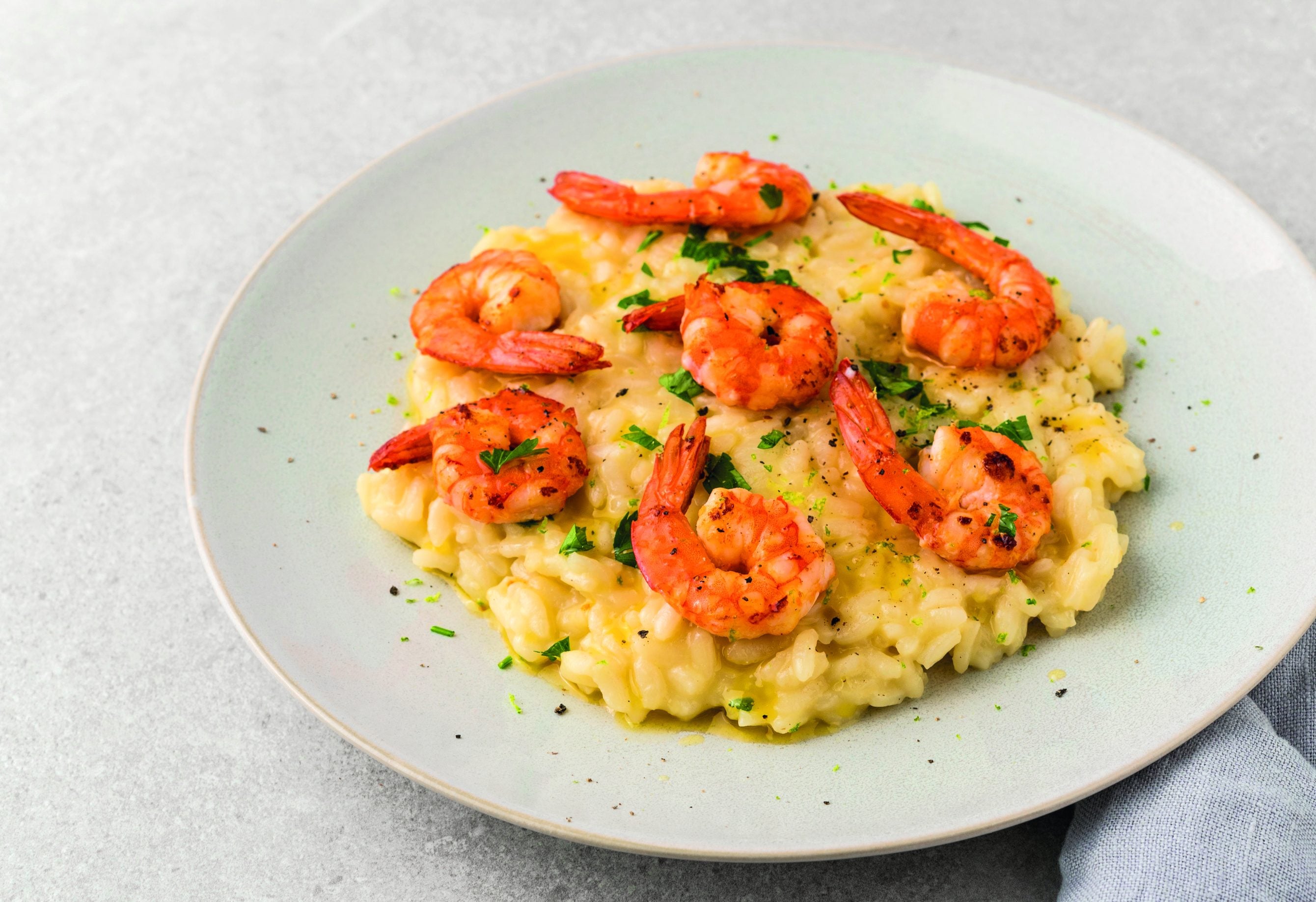 Creamy risotto topped with seared Bavarian shrimp, parsley and lime zest